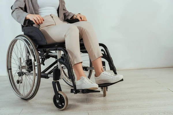 Vista ritagliata della donna disabile sulla sedia a rotelle su sfondo bianco — Foto stock