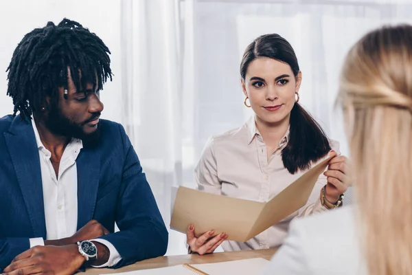 Enfoque selectivo de los reclutadores multiculturales que realizan una entrevista de trabajo con el empleado en la oficina - foto de stock