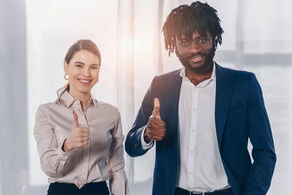 Reclutadores multiculturales con pulgares arriba sonriendo y mirando a la cámara - foto de stock