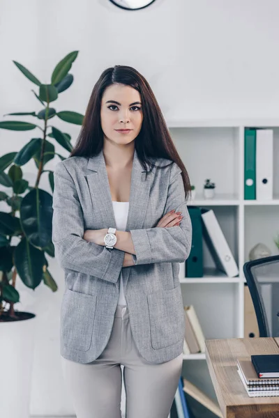Front view of recruiter with crossed arms looking at camera in office — Stock Photo