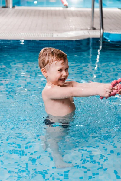 Щасливий малюк грає з гумовою іграшкою в басейні — стокове фото