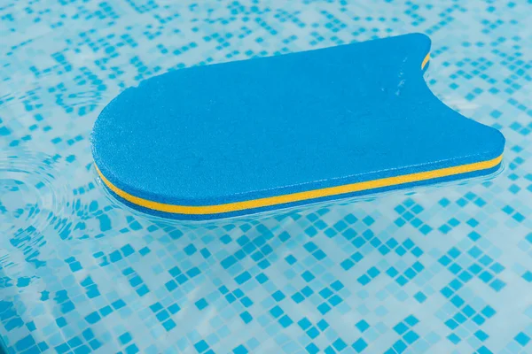Flutter board in swimming pool with blue water — Stock Photo