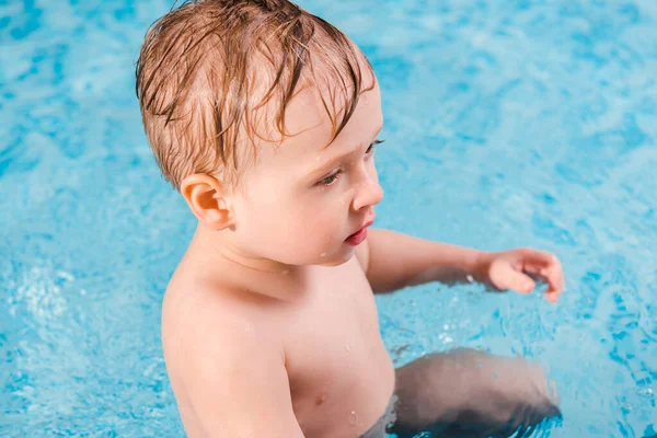 Selective focus of cute toddler boy in swimming pool — Stock Photo