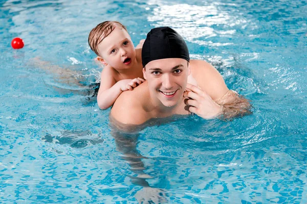 Treinamento feliz natação treinador e criança menino na piscina — Fotografia de Stock