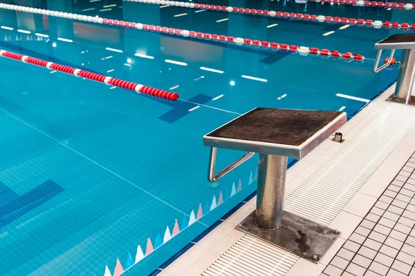 Bloc de plongée près de la piscine avec eau bleue — Photo de stock