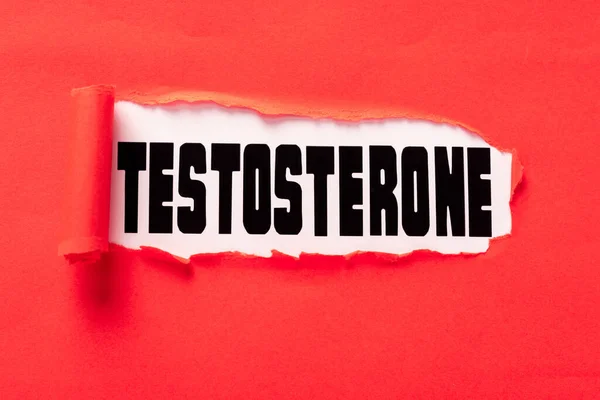 Lettrage de testostérone sur la surface blanche dans le trou de papier rouge — Photo de stock