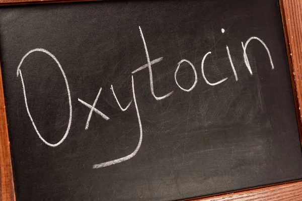 Close up view of lettering oxytocin on blackboard with wooden frame — Stock Photo