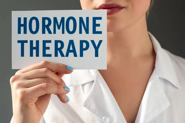 Vue agrandie d'un médecin tenant une carte avec lettrage hormonal isolé sur gris — Photo de stock