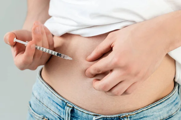 Cropped view of man doing hormonal injection in belly isolated on grey — Stock Photo