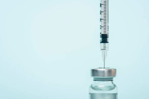 Close up view of jar of hormonal vaccine and syringe isolated on blue — Stock Photo