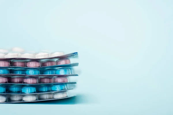 Vista de perto de blisters empilhados com pílulas hormonais na superfície azul com espaço de cópia — Fotografia de Stock