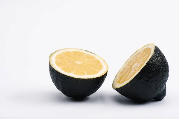 Moitiés de citron juteux et mûr sur blanc — Photo de stock