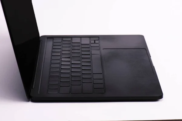 Schwarzer Laptop mit leerem Bildschirm auf weißem Hintergrund — Stockfoto