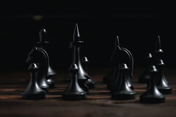 Messa a fuoco selettiva di figure scacchistiche su superficie testurizzata isolata su nero — Foto stock