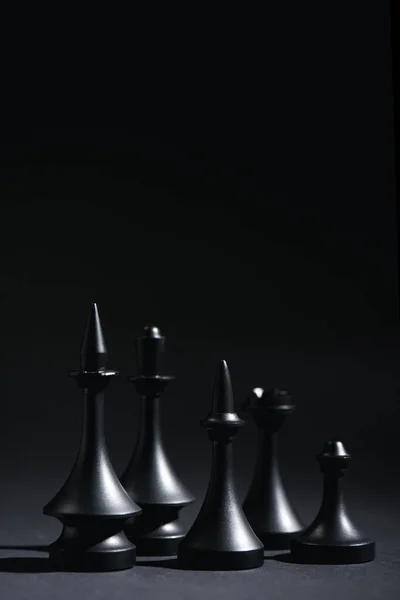Figure scacchistiche su nero con spazio di copia — Foto stock