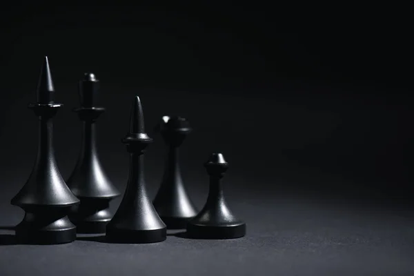Figure scure di scacchi su nero con spazio di copia — Foto stock