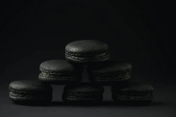 Dark and delicious macarons on black with copy space — Stock Photo