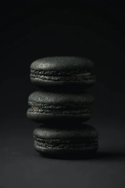 Macarons doces e escuros em preto com espaço de cópia — Fotografia de Stock
