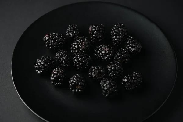 Vista superior de la placa con moras orgánicas y sabrosas en negro - foto de stock