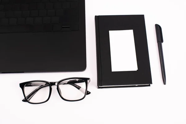 Vista superior de la computadora portátil, portátil, pluma, tarjeta en blanco y gafas aisladas en blanco - foto de stock