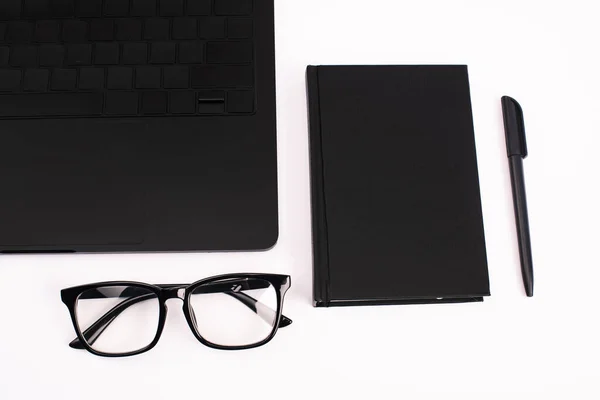 Vista superior de la computadora portátil, portátil, pluma y gafas aisladas en blanco - foto de stock