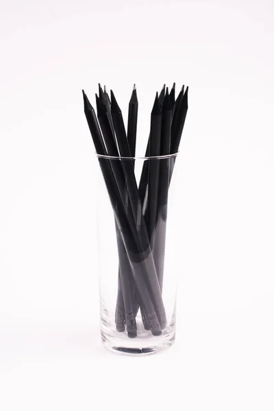 Чорні та дерев'яні олівці в склі ізольовані на білому — стокове фото