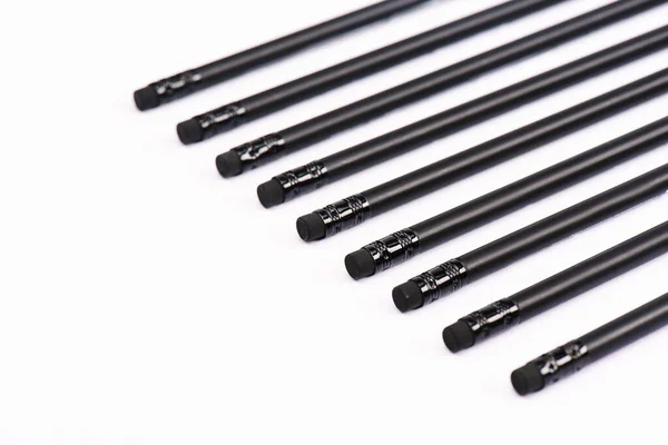 Enfoque selectivo de lápices negros con borradores aislados en blanco - foto de stock