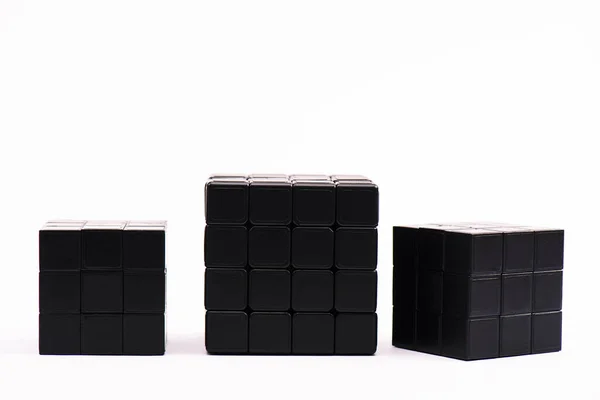 KYIV, UKRAINE - FEBRUARY 21, 2020: Black rubik cubes for strategy game on white — стокове фото