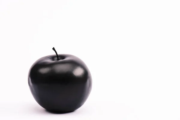 Manzana negra y nutritiva en blanco con espacio para copiar - foto de stock