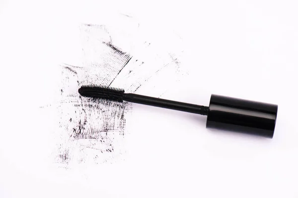 Top view of smudged mascara near mascara brush on white — Stock Photo