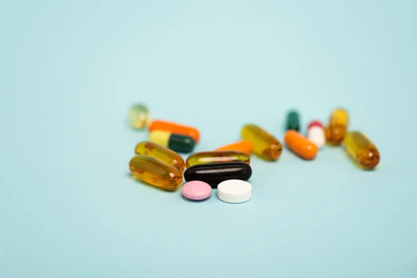 Close up view of colorful pills on blue surface — Stock Photo