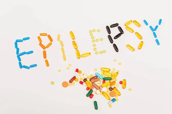 High angle with of epilepsy lettering near pills on white background — Stock Photo