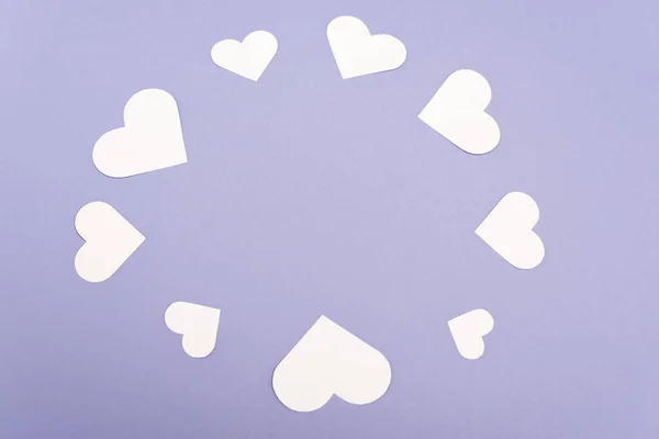 Рамка з білих паперових сердець ізольована на фіолетовому — стокове фото