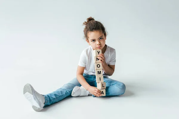 Bambino riccio africano americano vicino a cubi di legno con scritte di alimenti su bianco — Foto stock