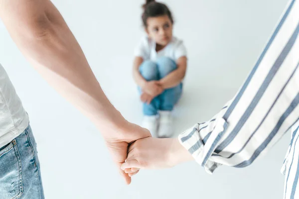 Selective focus of foster parents holding hands near african american adopted daughter on white — Stock Photo