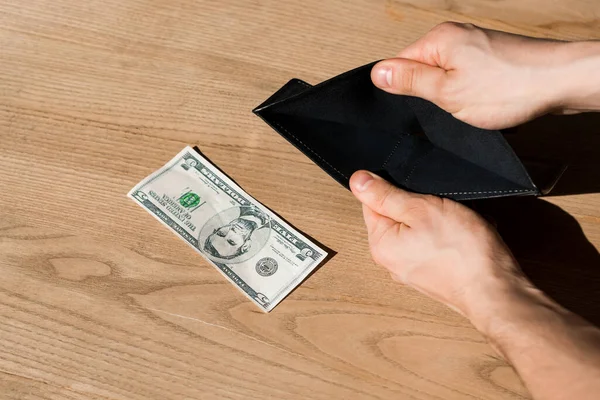 Cropped view of man holding empty wallet near dollar banknote — Stock Photo