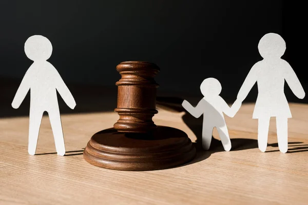 Paper people near wooden gavel on black, divorce concept — Stock Photo