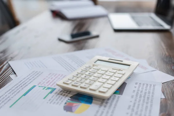 Calculator with papers on table in office — Stock Photo