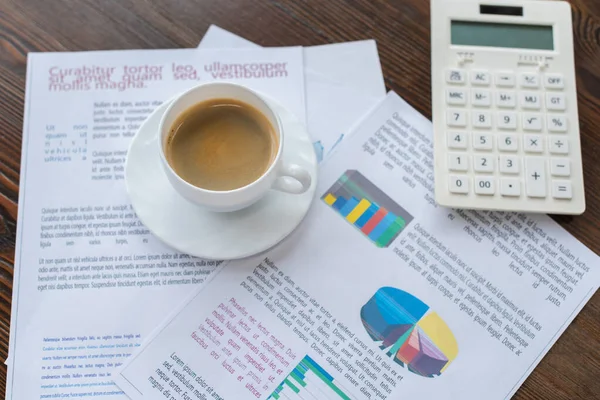 Selective focus of cup of coffee on papers near calculator on table — Stock Photo