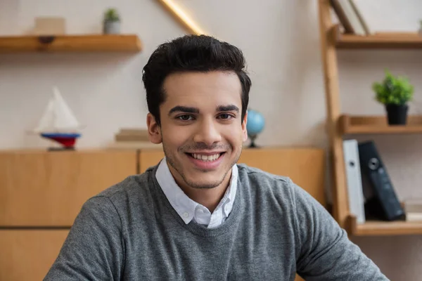 Porträt eines Geschäftsmannes, der im Büro lächelt und in die Kamera blickt — Stockfoto