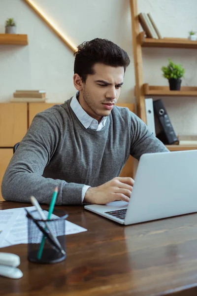 Focus selettivo dell'uomo d'affari che lavora con il computer portatile a tavola in ufficio — Foto stock