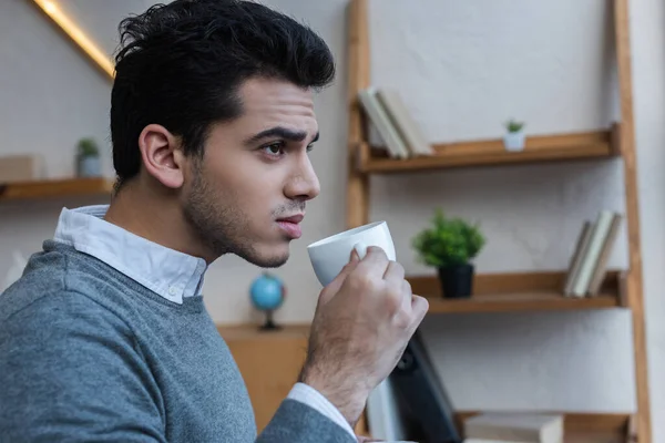 Uomo d'affari premuroso con tazza di caffè in ufficio — Foto stock