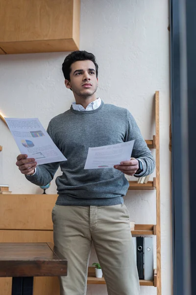 Selective focus of thoughtful businessman with papers in office — Stock Photo