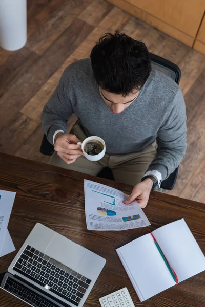 Vue aérienne de l'homme d'affaires avec tasse de café et de papier à table — Photo de stock