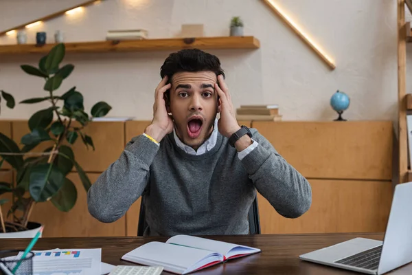 Empresario sorprendido mirando la cámara en la mesa en la oficina - foto de stock