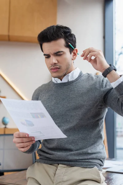 Concentrated businessman looking at paper in office — Stock Photo