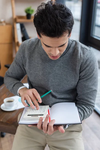 Empresário com lápis e notebook usando calculadora no escritório — Fotografia de Stock