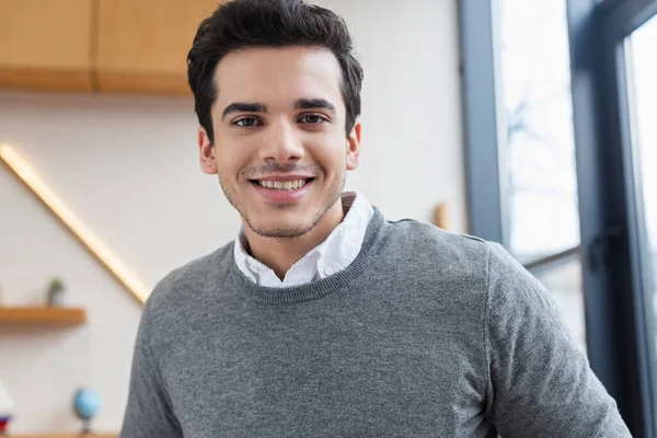 Retrato del hombre de negocios mirando a la cámara y sonriendo en la oficina - foto de stock