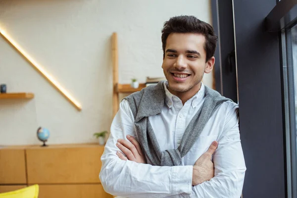 Empresário com braços cruzados sorrindo no cargo — Fotografia de Stock