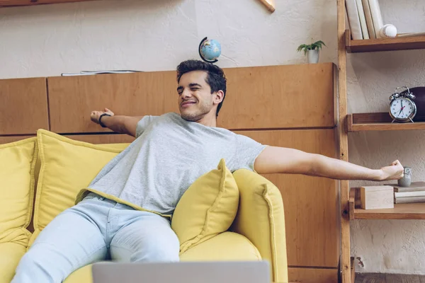 Man stretching himself on sofa in living room — Stock Photo